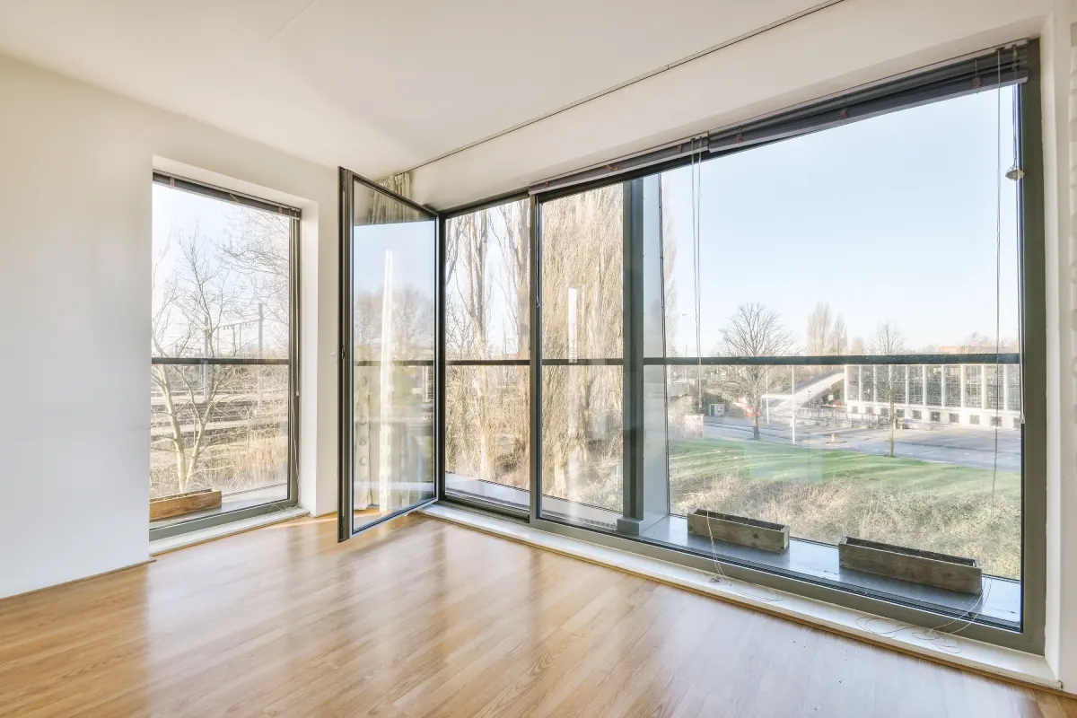 Zwei Handwerker installieren ein neues Fenster an einem Gebäude