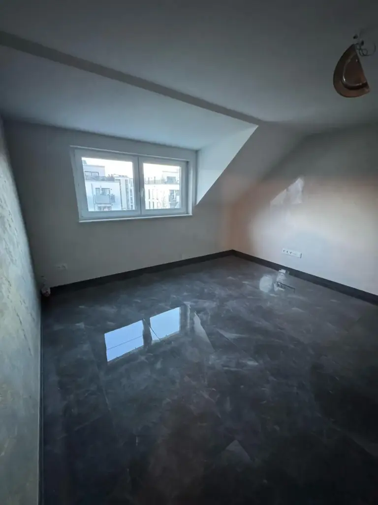 Dachgeschoss-Zimmer mit Dachschraege und glaenzendem Boden in Gruenwetterbach