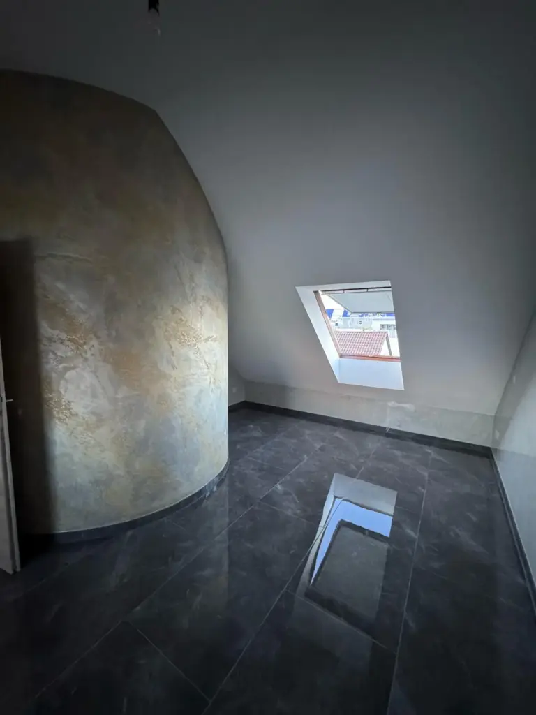 Raum mit geschwungener Wand im sanierten Dachgeschoss in Gruenwetterbach
