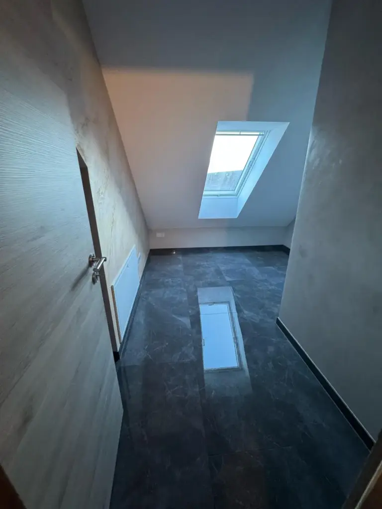 Dachgeschoss-Raum mit Dachfenster nach der Komplettsanierung in Gruenwetterbach