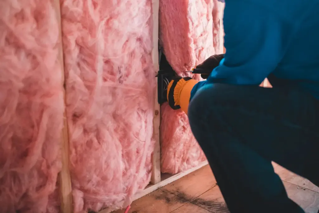 Handwerker bringt Wärmedämmung an einer Hauswand an – energetische Sanierung