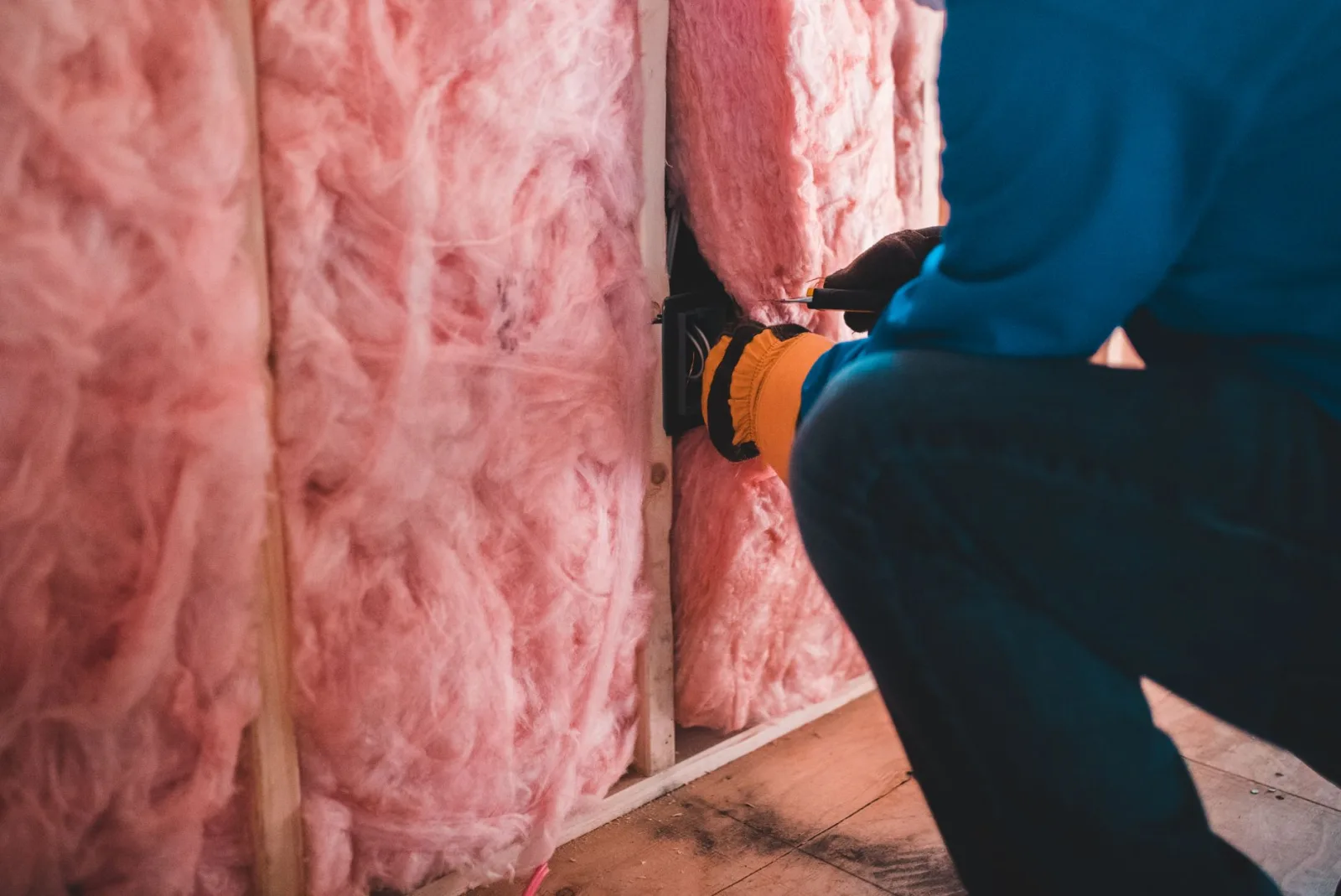Handwerker bringt Wärmedämmung an einer Hauswand an – energetische Sanierung