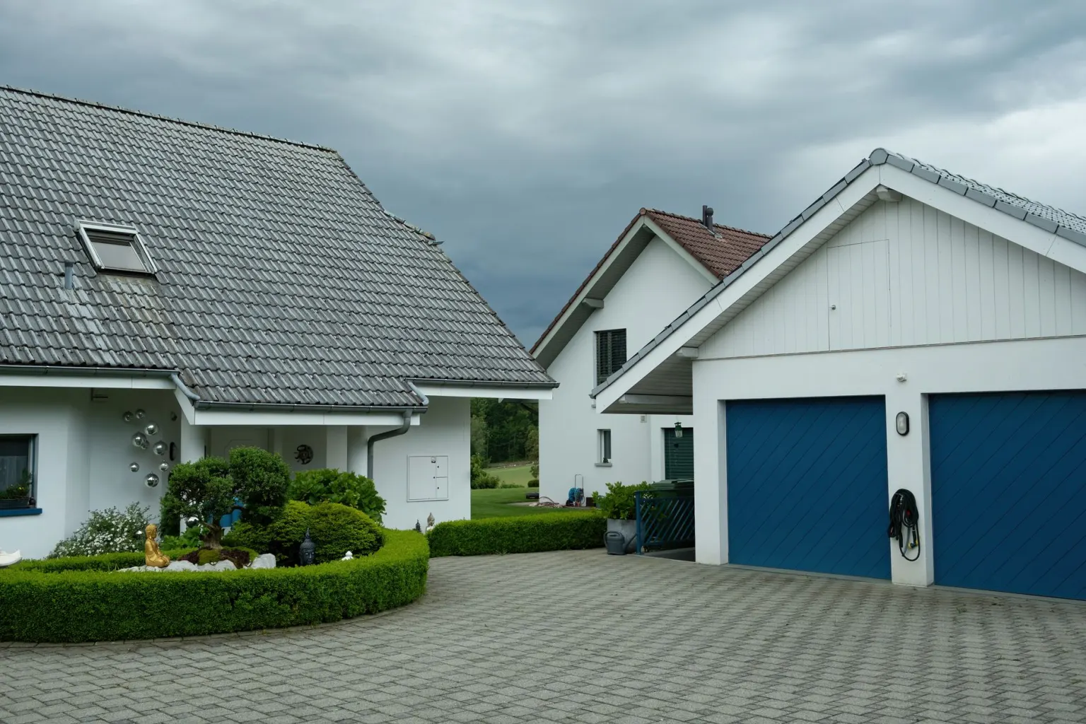 Modernes blaues Sektionaltor an der Garage eines Einfamilienhauses