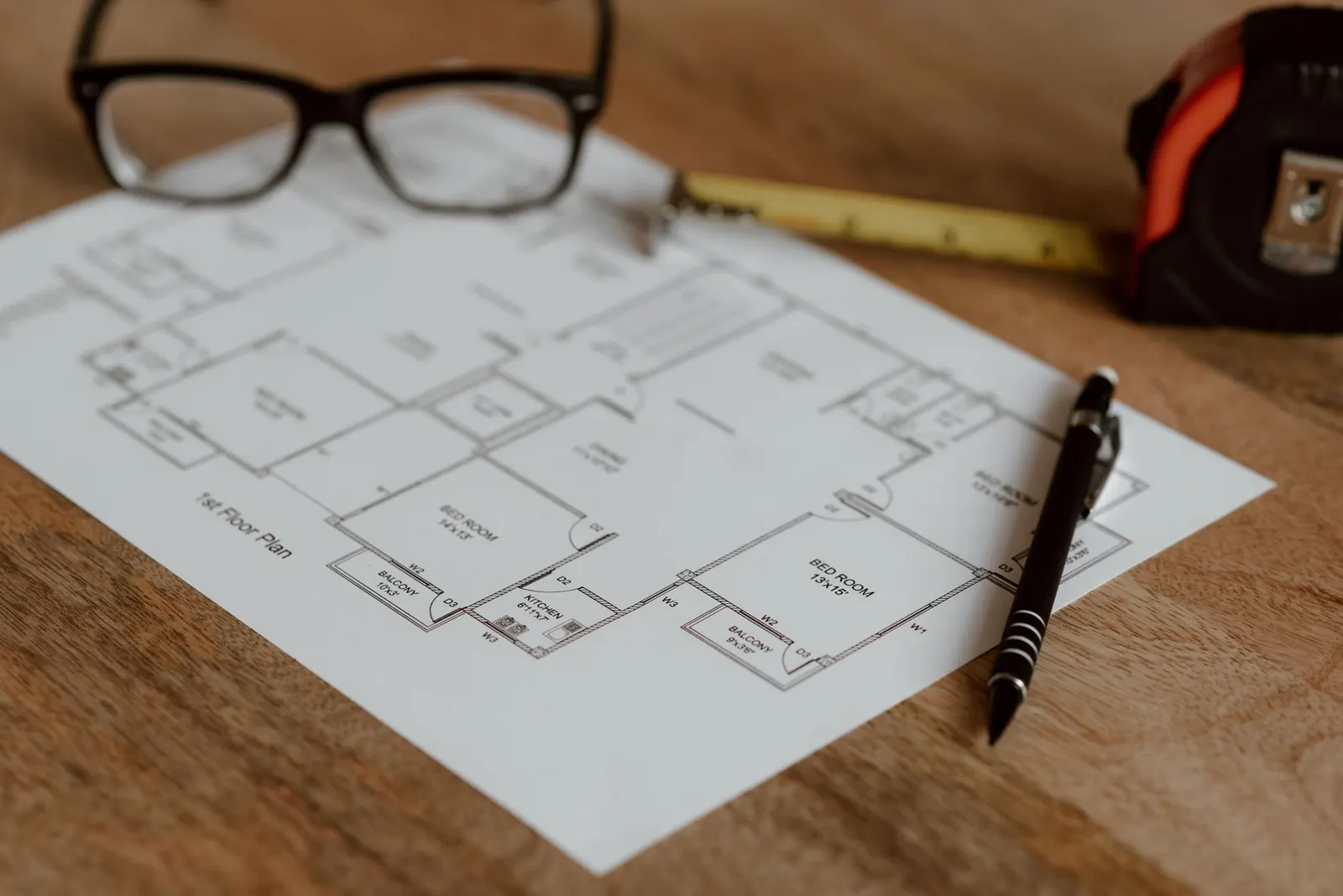 Grundriss eines Hauses wird mit Maßband und Stift geplant