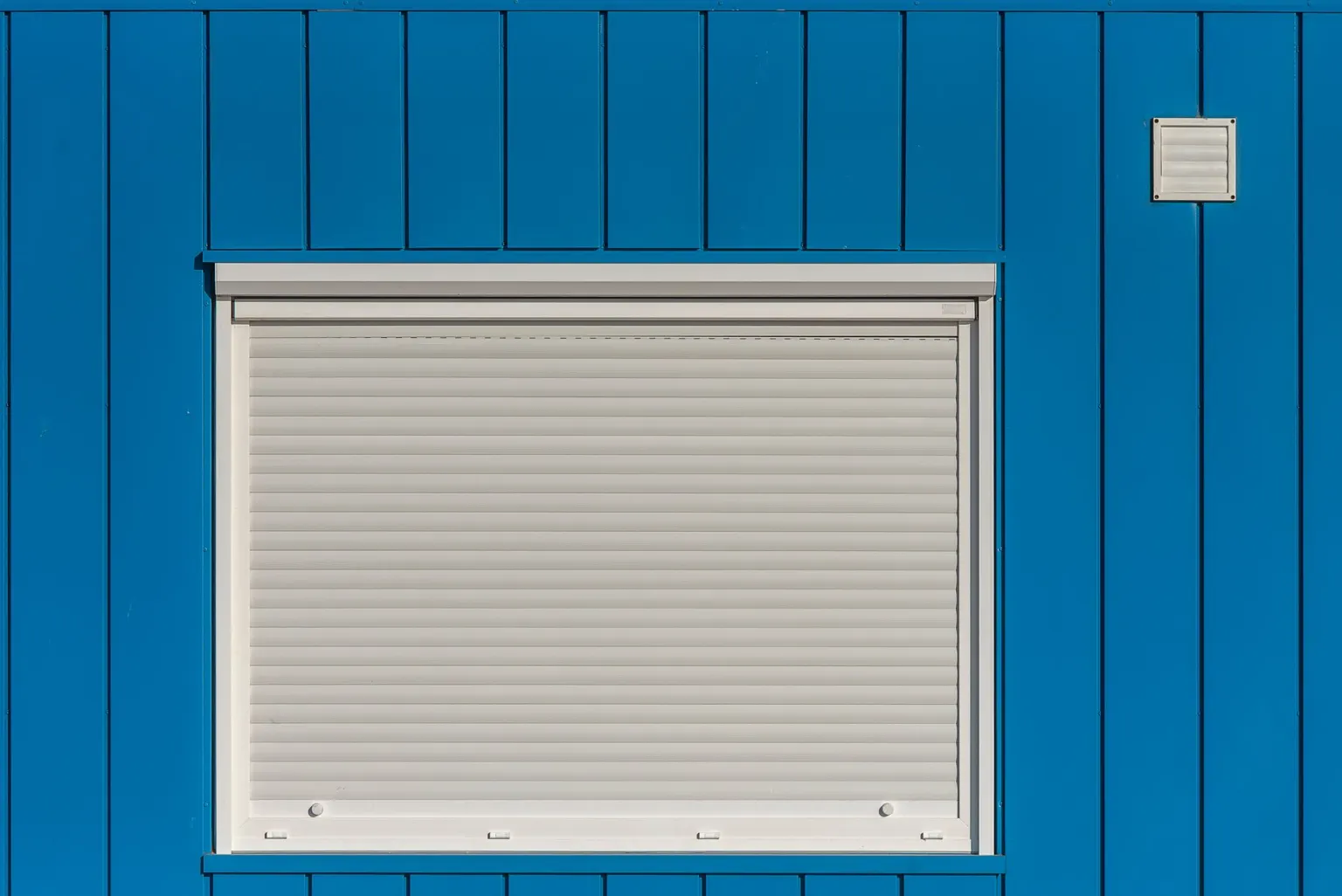 Detailaufnahme der Lamellen eines geschlossenen Rollladens am Fenster